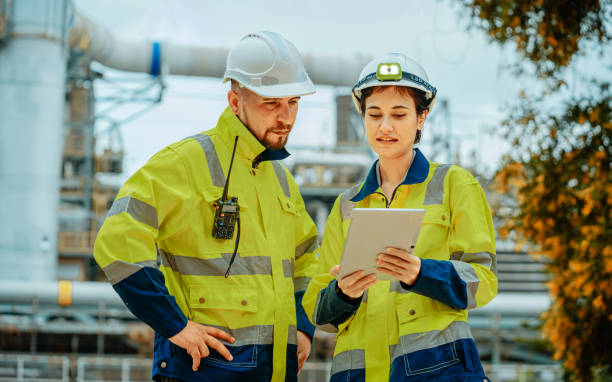 istock Engineers review project plans on a tablet at an industrial site under clear skies during the daytime 2196758916