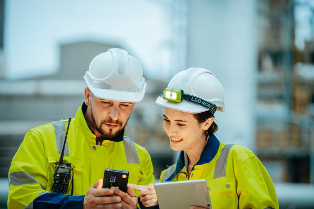 istock Construction workers collaborate on a digital project at a busy job site during the day 2196758919