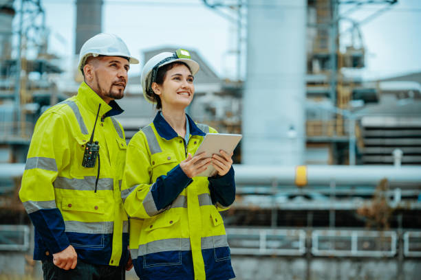istock Workers collaborate at industrial site while reviewing plans on tablet during daytime 2196758945