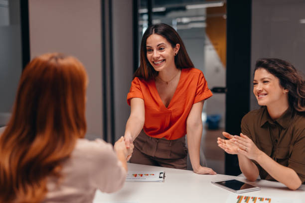 istock Businesswomen shaking hands after successful agreement in modern office 2196760268
