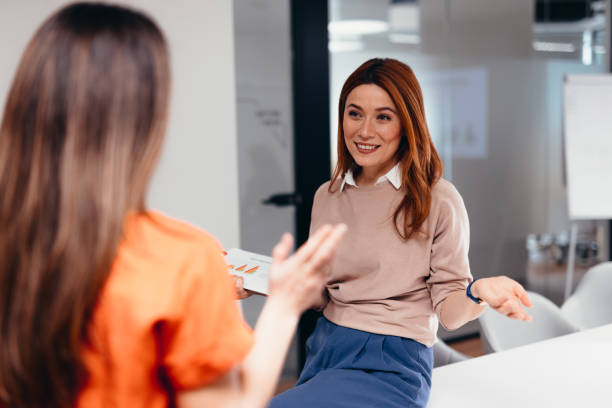 istock Two businesswomen discussing a project in the office using a tablet 2196760374