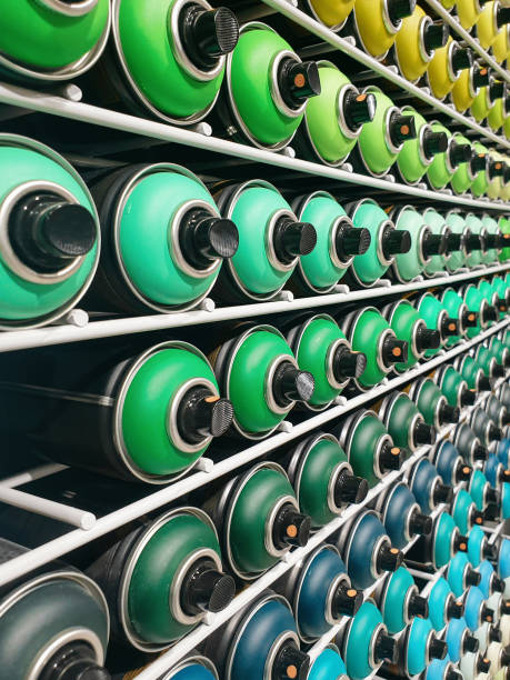Rows of green, teal and turquoise spray cans on shelves.
