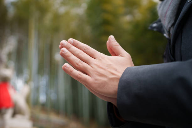 Close up to man joining his hands in prayer.