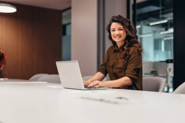 istock Smiling businesswoman working with laptop in modern office 2196764314