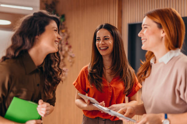 istock Three businesswomen laughing and talking during a work break 2196764366