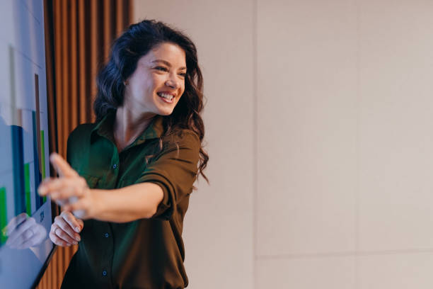 istock Businesswoman pointing at interactive whiteboard during a presentation 2196764481
