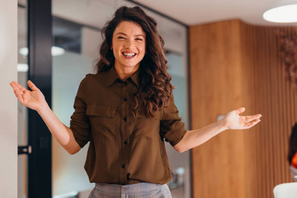 istock Young businesswoman gesturing and smiling during a presentation in a modern office 2196764640