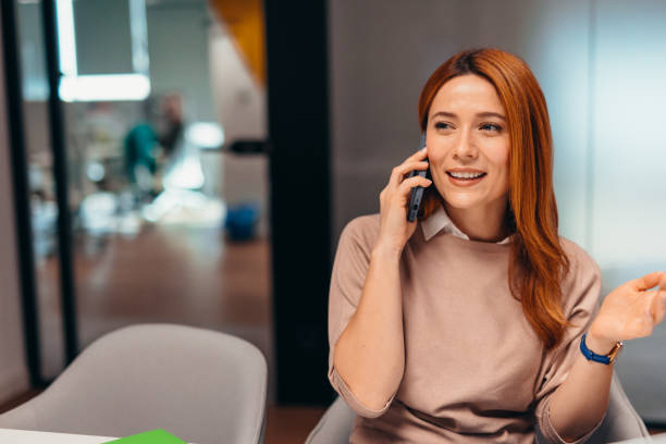 istock Smiling businesswoman talking on smartphone in modern office 2196764784