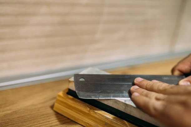 kitchen knife blade and grindstone on tile floor