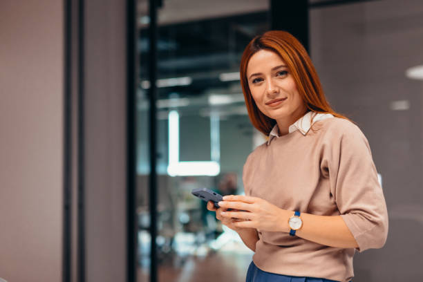istock Young businesswoman using smartphone in modern office 2196764830