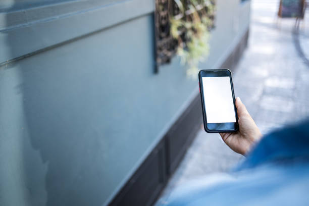 istock Over the shoulder view of a woman using mobile phone 2196765181