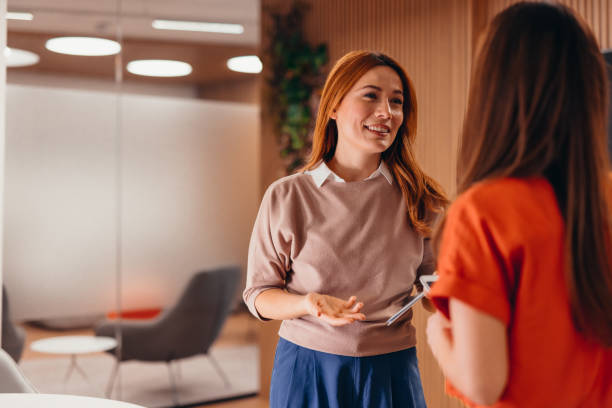 istock Two businesswomen discussing in modern office using tablet 2196765325
