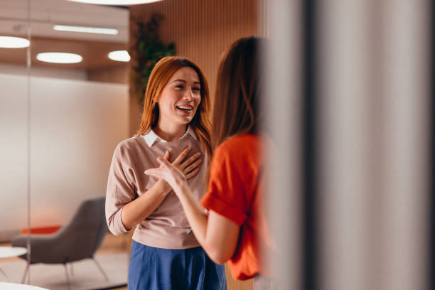 istock Two businesswomen chatting and smiling in modern office 2196765327