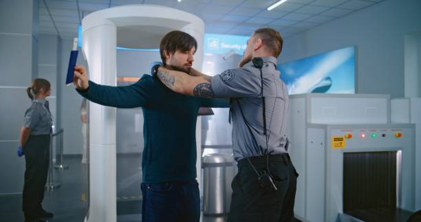 istock Man Passes Through Metal Detector Scanner. Security Officer Checks Documents, Inspects Passenger 2196767401