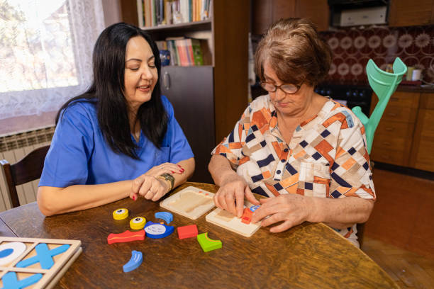 istock Assisting a Senior woman with Dementia in Creative Activities 2196771263
