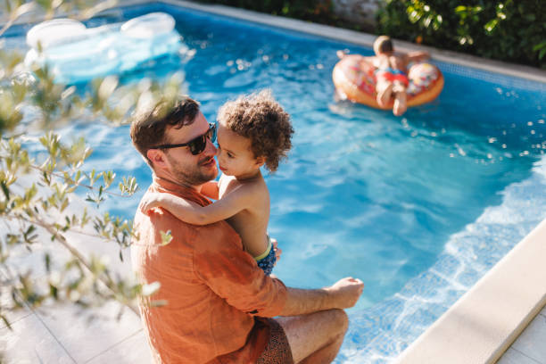 istock Father and Son Enjoying Poolside Vacation 2196771416