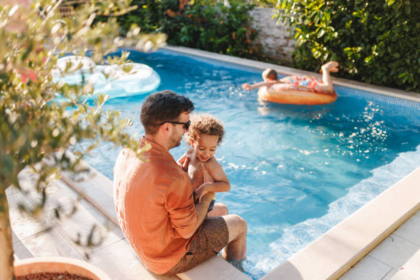 istock Father and Son Bonding at the Pool in a Joyful Vacation Moment 2196771440