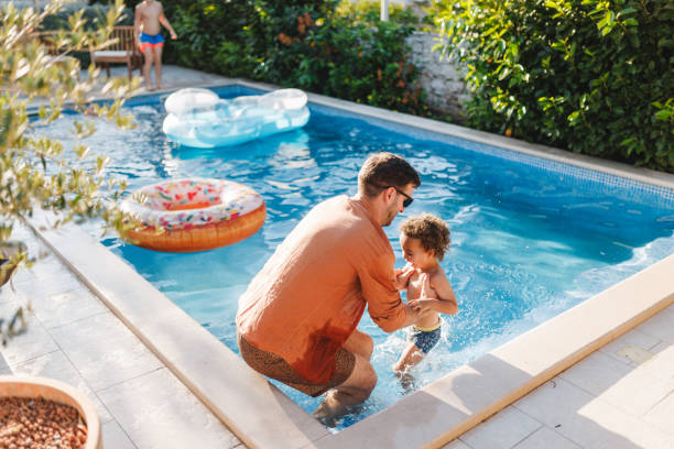 istock Father and Son Enjoy Bonding Time in the Pool 2196772956
