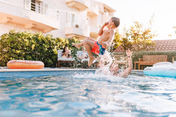 istock Father and Son Enjoying Summer Fun in Hotel Pool 2196773236