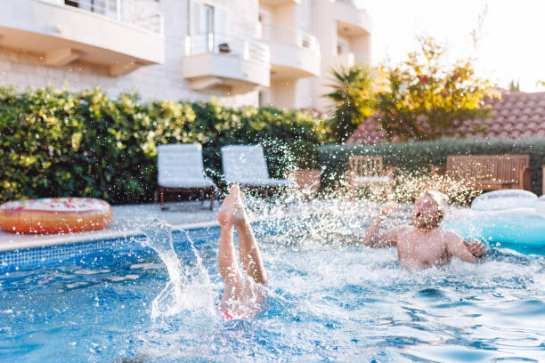 istock Father and Son Enjoying Splashing Fun in Hotel Pool 2196773244