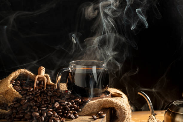 istock black coffee in coffee cup There are roasted coffee beans on the table. with a black background and dark colors 2196773512