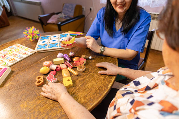 istock Nurse supporting an elderly woman with dementia in recognizing plastic objects 2196774092