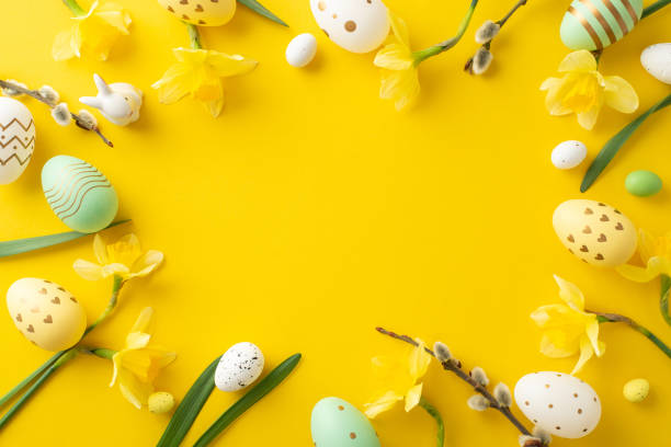 istock Easter-themed composition featuring colorful decorative eggs and fresh daffodils on yellow surface 2196774513
