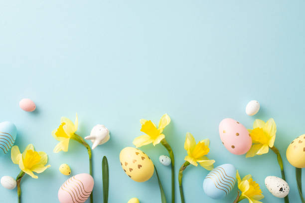 istock Festive composition featuring colorful Easter eggs with daffodil flowers arranged on a soft blue backdrop, symbolizing springtime and celebration 2196774515