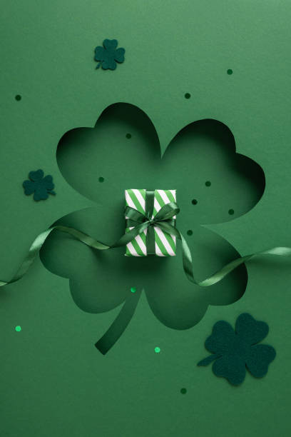 istock A vertical green-themed Saint Patrick's Day design featuring a clover motif and a small wrapped present, symbolizing celebration and festive spirit 2196774611
