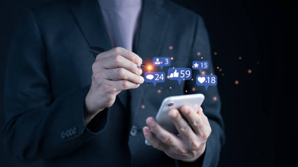 istock A man is texting and using emojis on his smartphone to interact with others. idea with star, like, message, email, and comment notification symbols over the screen of a smartphone 2196774625