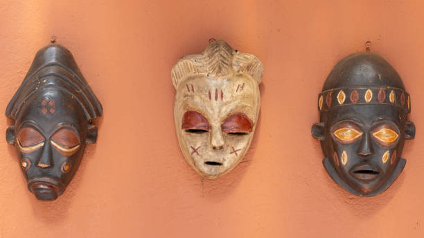 Beautiful African mask hanging on colorful wall in the sun, Symbol of culture of Indigenous of Tanzania