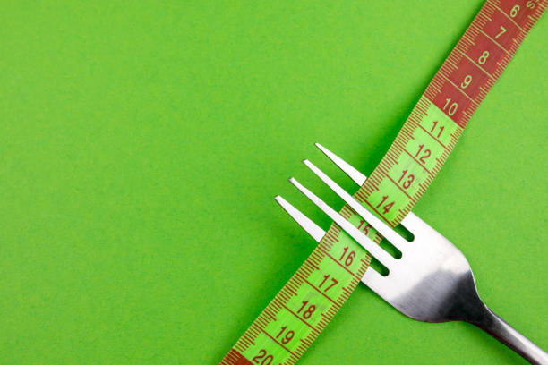 DIET letters written by cookies on white plate with silverware.\nDiet concepts.