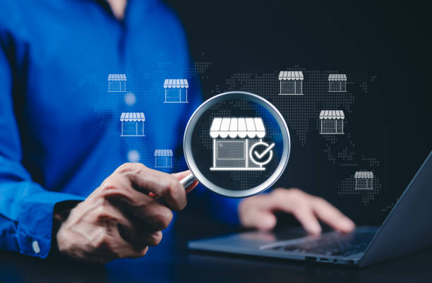 istock Local marketplace and e-commerce business concept. A person using a laptop with a magnifying glass focusing on a digital storefront, online marketplace, business growth, and e-commerce opportunities. 2196777152