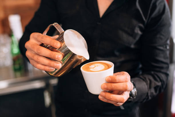 Barista Skillfully Pouring Latte Art Into a Cappuccino Cup