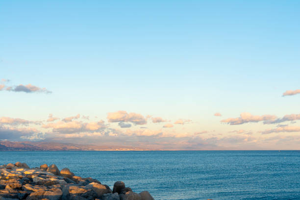 A Tranquil sunset on the sea with rocks in the foreground