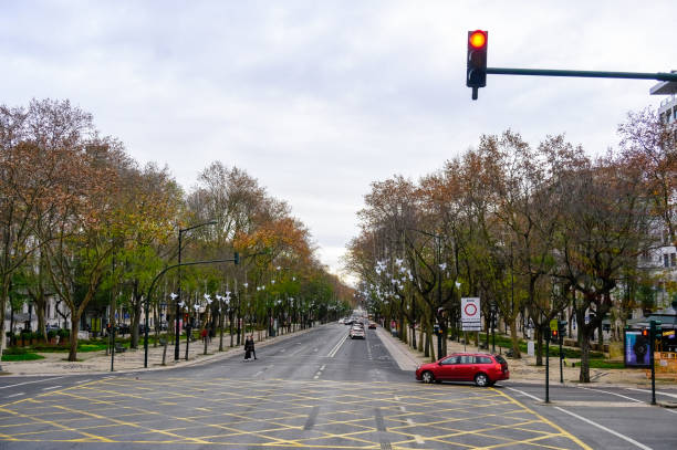 Lisbon, Portugal - January 6, 2025: A car driving on an intersection of the Avenida da Liberdade, overcast sky. Point of view from a tourist bus.