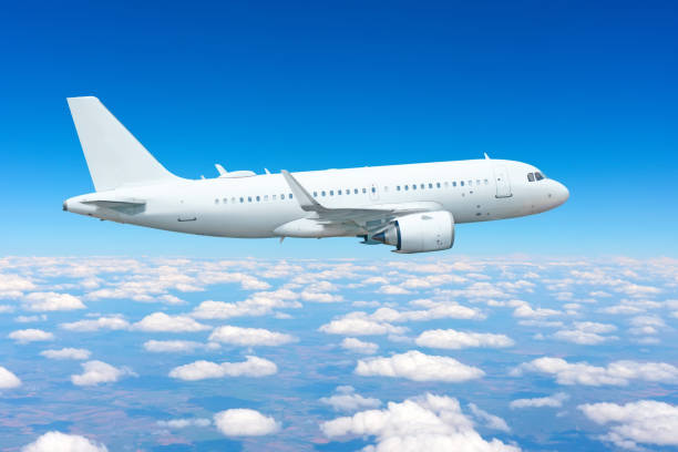 istock airplane soars gracefully through a bright blue sky, surrounded by fluffy white clouds, capturing the essence of air travel on a clear day. 2196785418