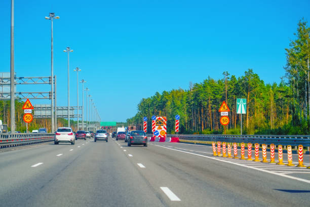 istock The bustling traffic flow on a sunny day is accompanied by road construction signs, creating a lively atmosphere and altering the usual commute experience 2196785579