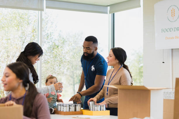 istock Volunteers sorting canned goods at a food drive 2196786727