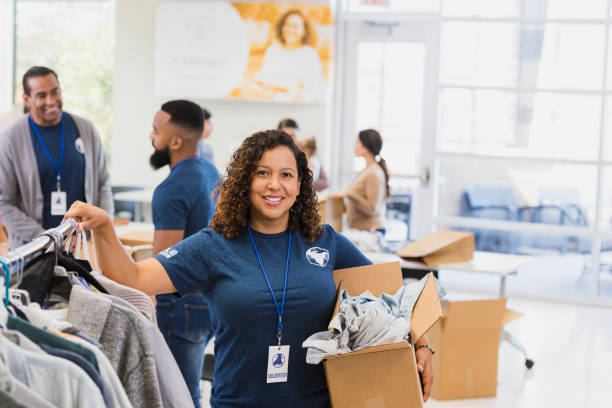 istock Smiling Volunteer Woman Sorting Clothes at Charity 2196786731
