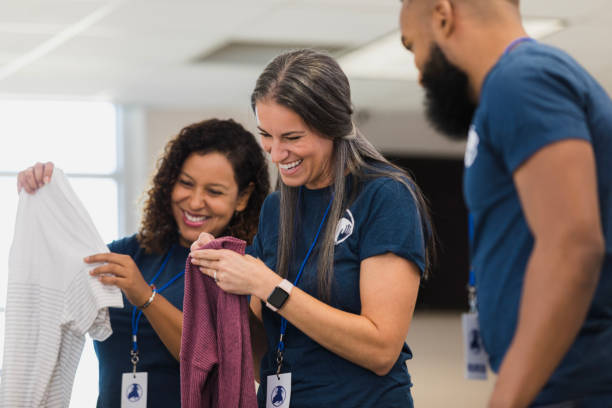 istock Happy Volunteers Sorting Clothes at a Charity 2196786736
