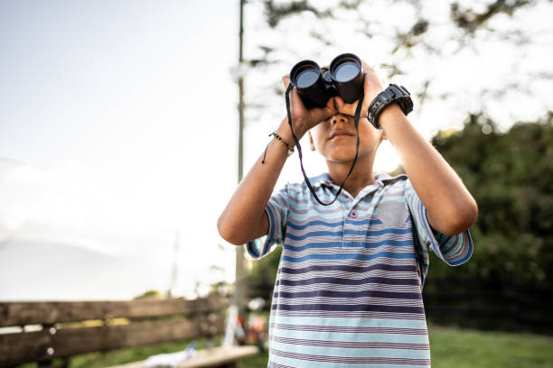 istock Child boy looking at the view through binoculars on a farm 2196797219