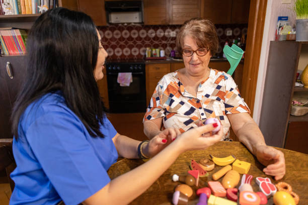 istock Nurse Supporting Elderly Woman with Dementia in Hands-On Activity 2196798564