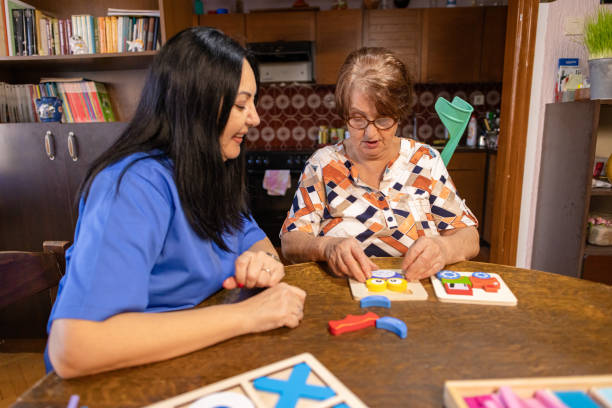 istock Nurse and Elderly Woman with Alzheimer’s Sharing a Fun Activity 2196799422