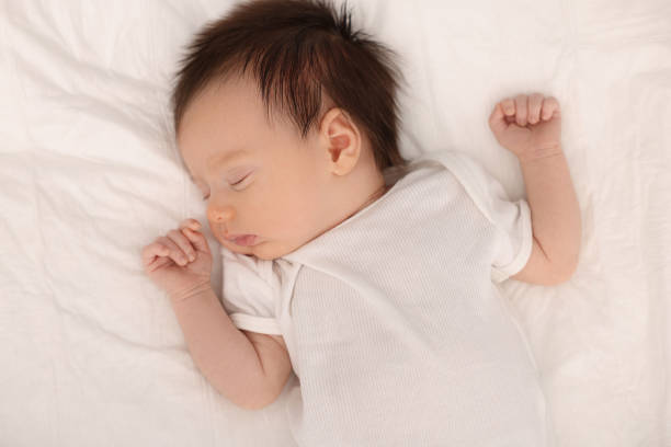 istock Cute newborn baby sleeping on bed, top view 2196800141