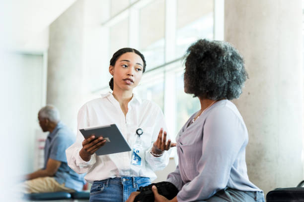 istock Two Women in Discussion, Healthcare Worker Using Tablet 2196801113