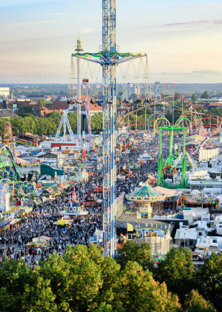 Panoramic photo of the Munich Oktoberfest with thousands of visitors, rides and marquees in a lively atmosphere