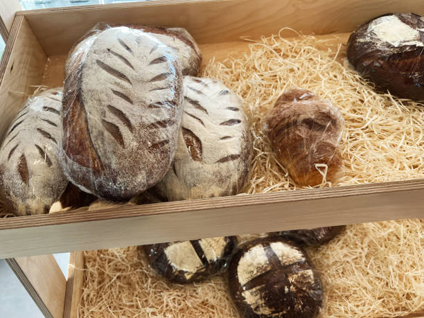 Freshly baked assorted artisan breads displayed in a wooden basket for sale
