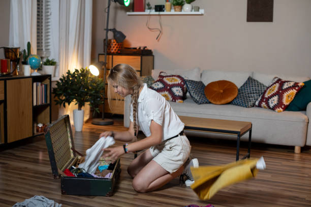 istock Joyfully sorting through colorful clothes in an old vintage suitcase, discovering treasures 2196804961