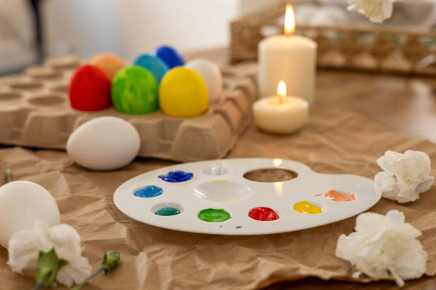 istock Colorful Easter eggs being painted on a spring day with candles and flowers nearby 2196805433